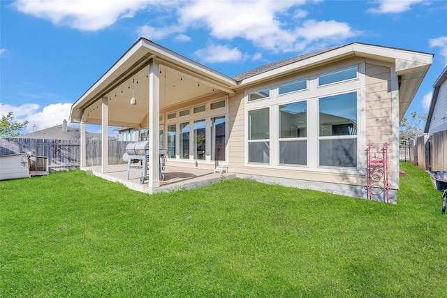 rear view of property featuring a patio and a lawn