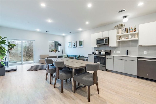 dining area featuring light wood-type flooring and sink