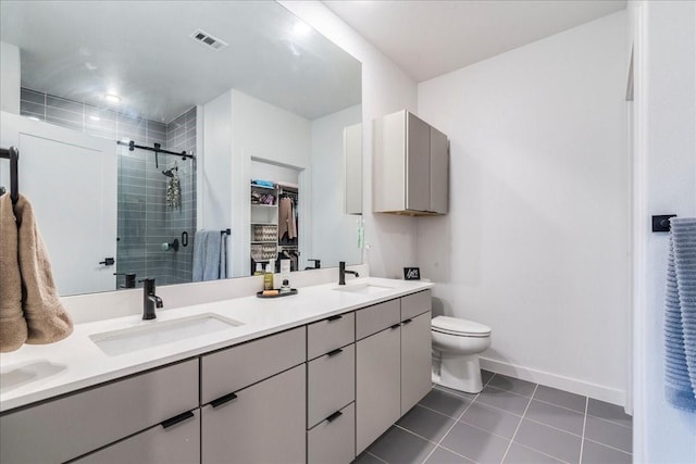 bathroom with toilet, a shower with door, tile patterned floors, and vanity