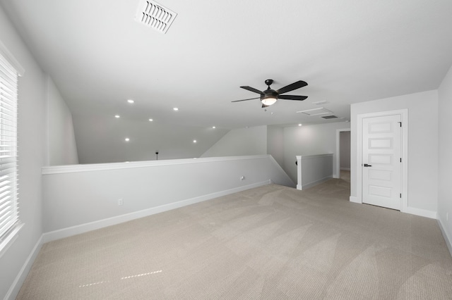 additional living space with vaulted ceiling, light colored carpet, and ceiling fan