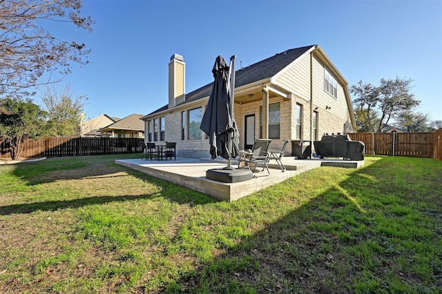 back of property with a lawn and a patio area