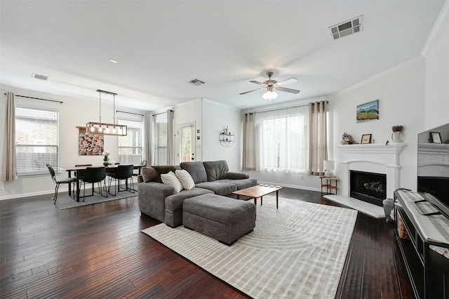 living room with ceiling fan, crown molding, and a healthy amount of sunlight