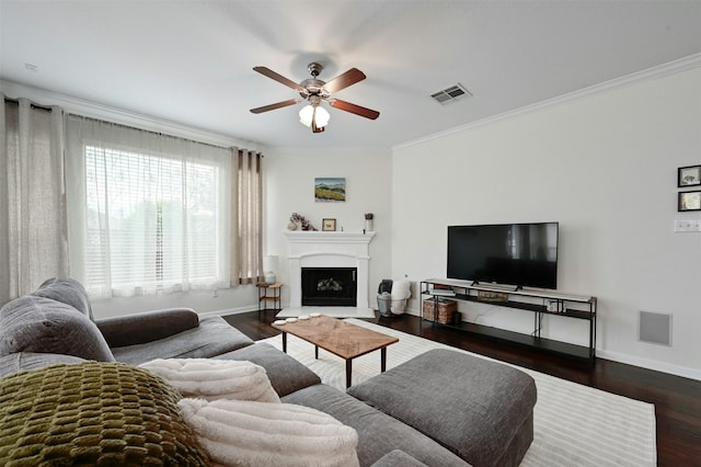 living room with ceiling fan, ornamental molding, and dark wood-type flooring