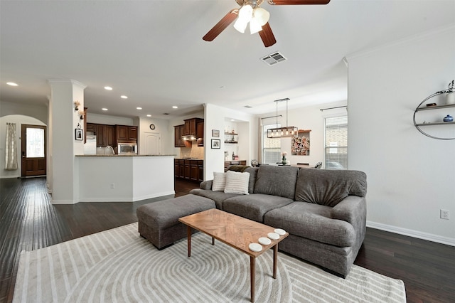 living room with ornamental molding, ceiling fan, a wealth of natural light, and dark hardwood / wood-style floors