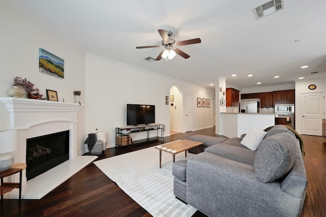 living room with hardwood / wood-style floors, ceiling fan, and crown molding