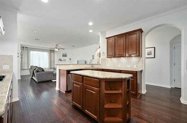 kitchen featuring kitchen peninsula, dishwasher, a center island, ceiling fan, and sink