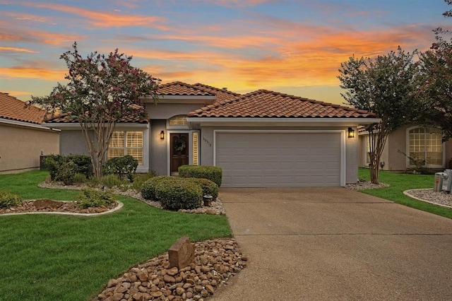 mediterranean / spanish-style home with a garage and a lawn