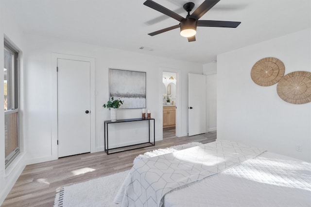 bedroom with ceiling fan, light hardwood / wood-style floors, and connected bathroom