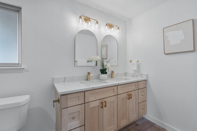 bathroom featuring toilet, vanity, and hardwood / wood-style floors