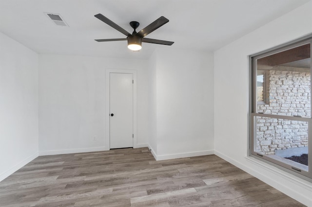 empty room with ceiling fan and light hardwood / wood-style floors