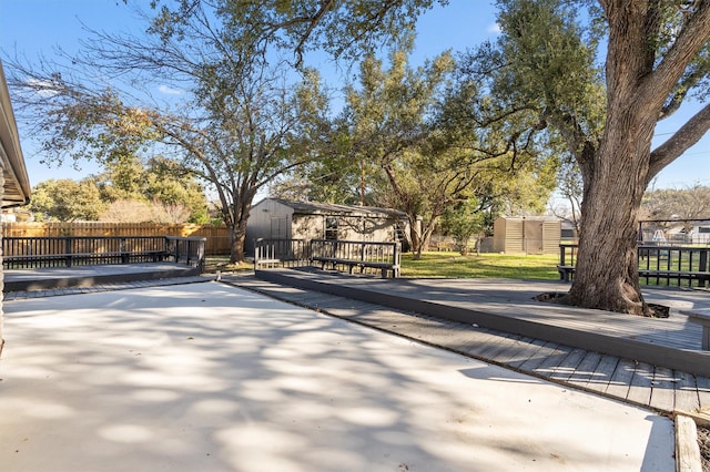 view of patio featuring a storage unit and a wooden deck