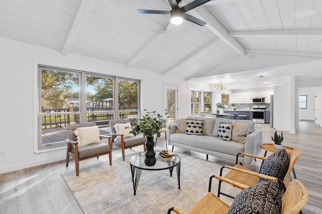 living room featuring light hardwood / wood-style floors, vaulted ceiling with beams, and ceiling fan with notable chandelier