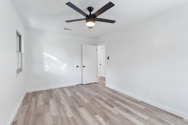 empty room with ceiling fan and light hardwood / wood-style floors