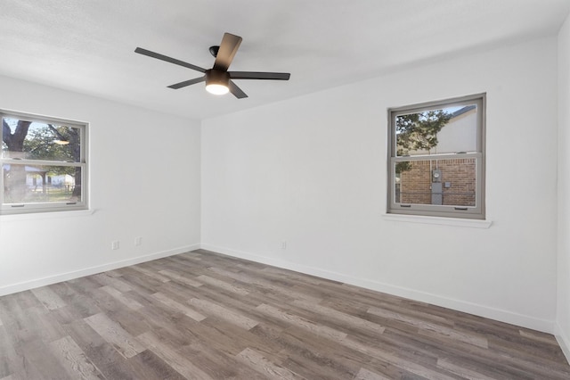 empty room with ceiling fan and light hardwood / wood-style floors