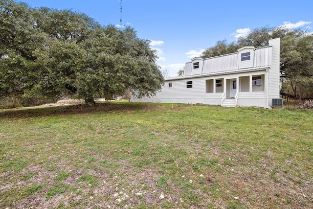 back of property featuring cooling unit and a yard