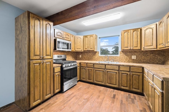 kitchen featuring sink, appliances with stainless steel finishes, light hardwood / wood-style floors, decorative backsplash, and beam ceiling