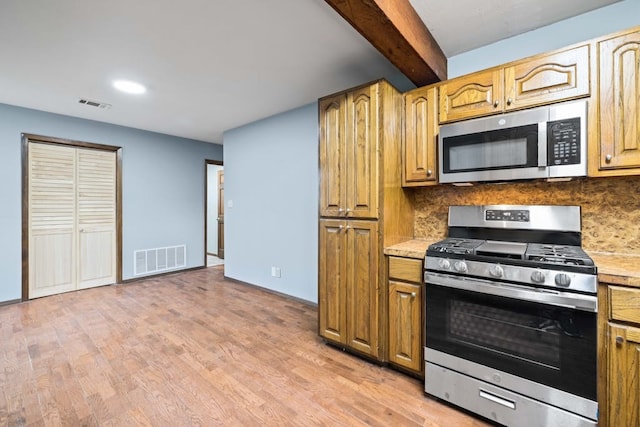 kitchen with stainless steel appliances, light wood-type flooring, beam ceiling, and decorative backsplash