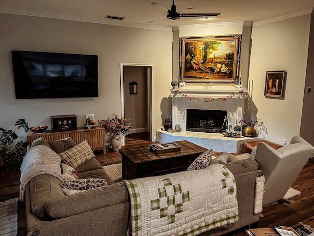 living room featuring crown molding, a brick fireplace, ceiling fan, and hardwood / wood-style flooring