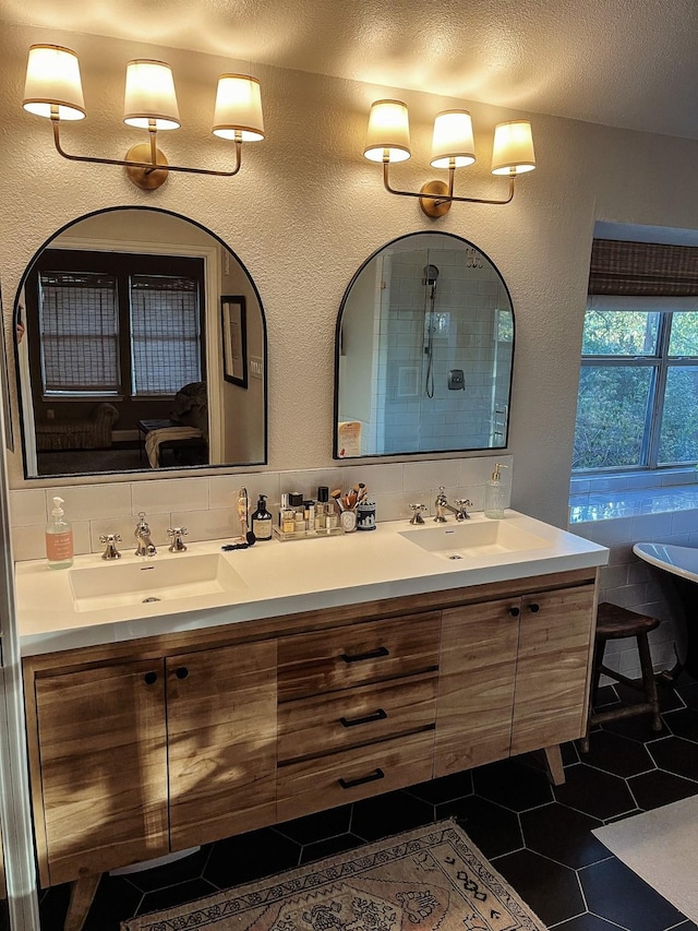 bathroom with vanity, tile patterned flooring, a textured ceiling, and backsplash