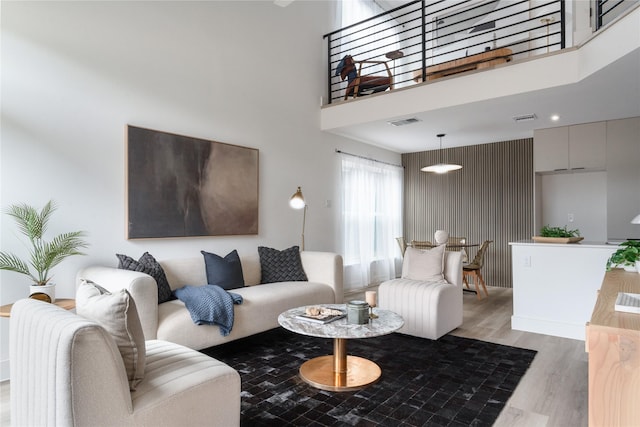 living room with a towering ceiling and light hardwood / wood-style floors