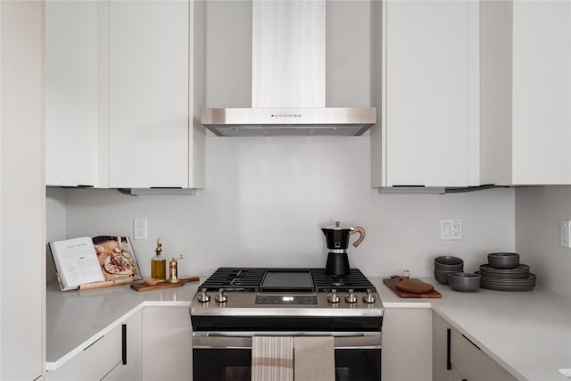 kitchen with white cabinets, stainless steel gas range, and wall chimney exhaust hood