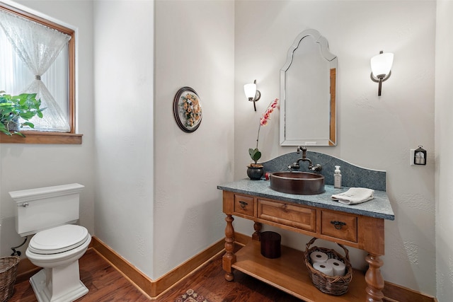 bathroom featuring toilet, vanity, and hardwood / wood-style flooring