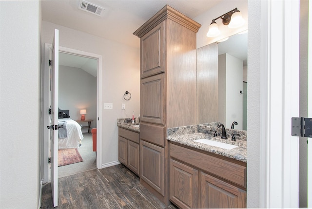 bathroom featuring hardwood / wood-style floors, vaulted ceiling, and vanity