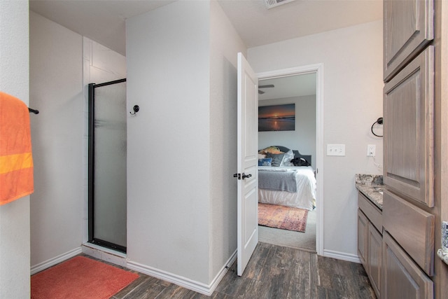 bathroom featuring hardwood / wood-style flooring, walk in shower, and vanity