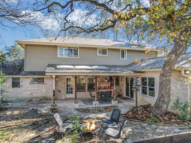 rear view of property featuring an outdoor fire pit and a patio