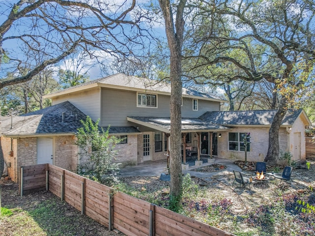 rear view of property with a patio area and an outdoor fire pit