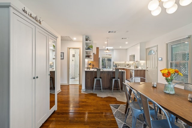 dining area featuring a chandelier, dark hardwood / wood-style flooring, and sink