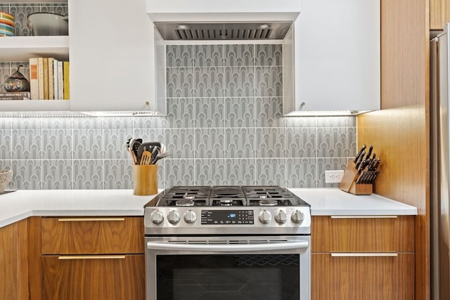 kitchen featuring custom exhaust hood, tasteful backsplash, and stainless steel gas range oven