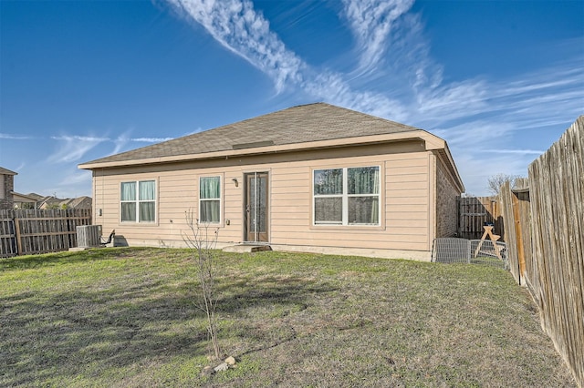 back of house with central AC unit and a lawn