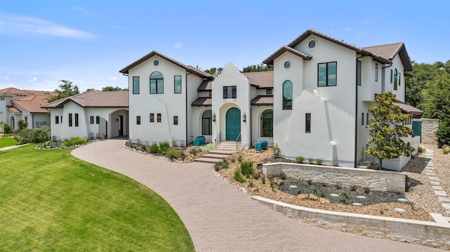 mediterranean / spanish-style home featuring a front yard