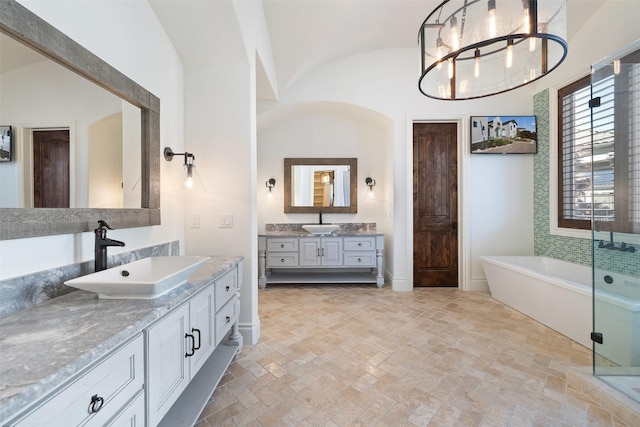 bathroom featuring a notable chandelier, lofted ceiling, vanity, brick ceiling, and plus walk in shower