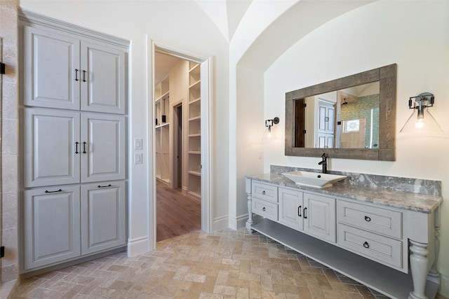 bathroom with walk in shower, vaulted ceiling, and vanity