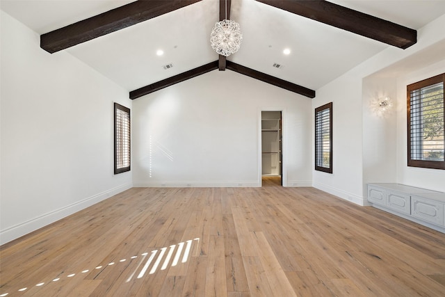 unfurnished living room with a notable chandelier, lofted ceiling with beams, and light hardwood / wood-style flooring