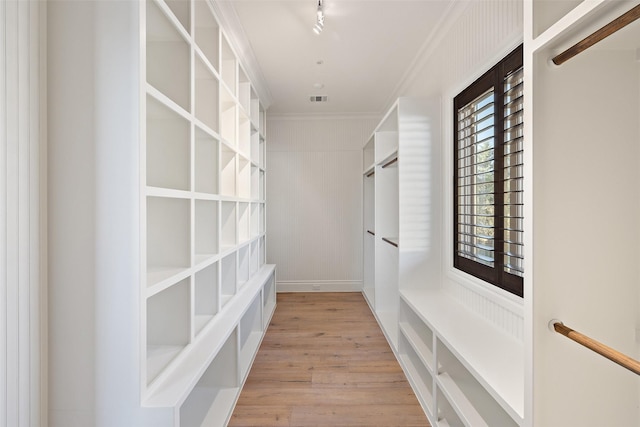 walk in closet with light hardwood / wood-style floors