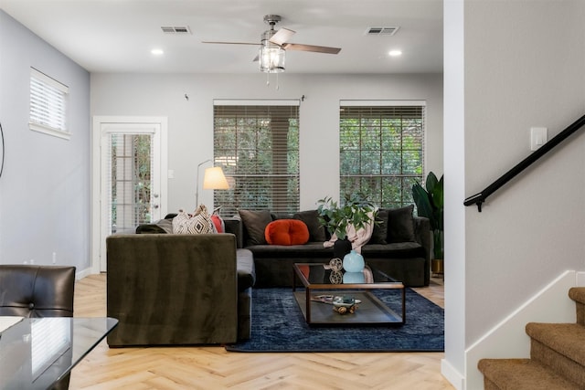 living area with ceiling fan and light parquet flooring