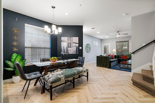 dining room featuring ceiling fan with notable chandelier and light parquet floors