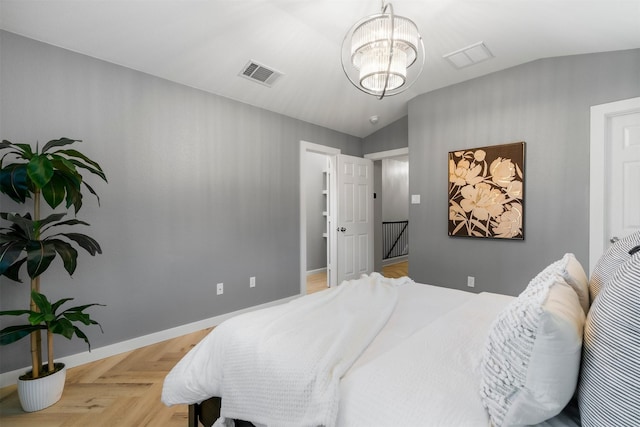 bedroom with lofted ceiling, light parquet flooring, and an inviting chandelier