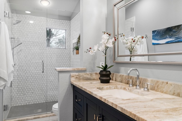 bathroom with toilet, an enclosed shower, and vanity