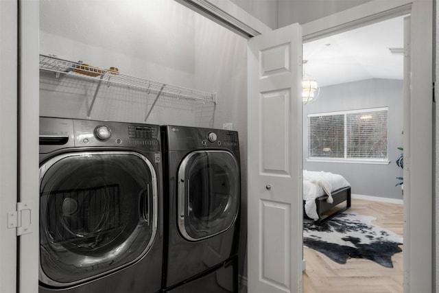 laundry room with parquet flooring and washing machine and clothes dryer