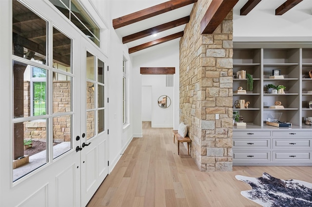 interior space with french doors, lofted ceiling with beams, and light hardwood / wood-style flooring