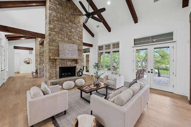 living room featuring beamed ceiling, ceiling fan, french doors, high vaulted ceiling, and a wealth of natural light