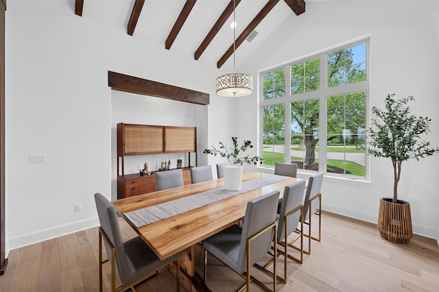 dining room with high vaulted ceiling, light wood-type flooring, and beam ceiling