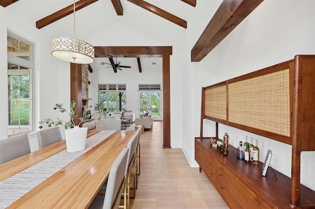 dining room featuring high vaulted ceiling, light wood-type flooring, ceiling fan, and beamed ceiling