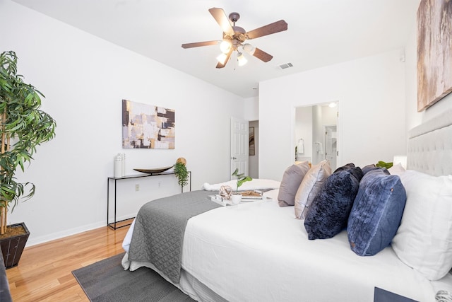 bedroom with wood-type flooring, ceiling fan, and connected bathroom