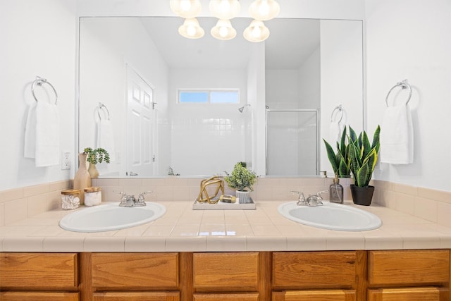 bathroom with a shower with door and vanity