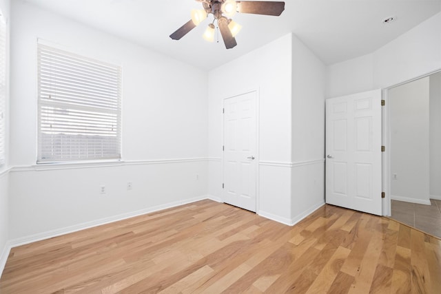 unfurnished bedroom with ceiling fan, light wood-type flooring, and a closet